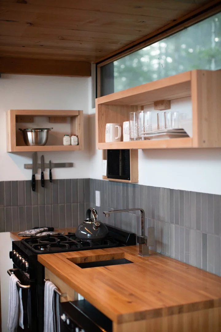 True Studio's kitchen includes an oven with propane-powered four-burner stove, a sink, and a fridge