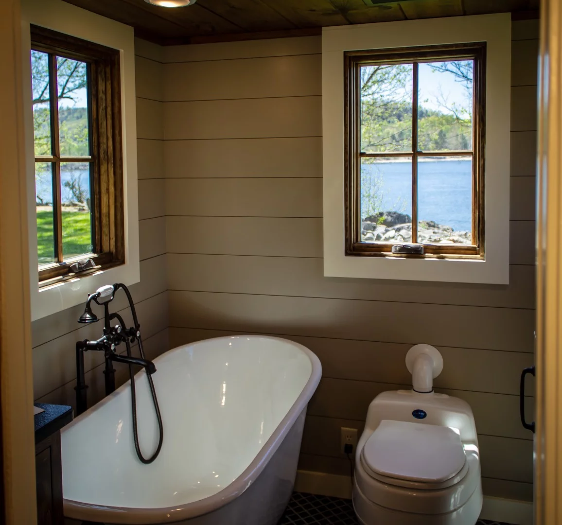 The Cedar House's bathroom includes a composting toilet and clawfoot bathtub