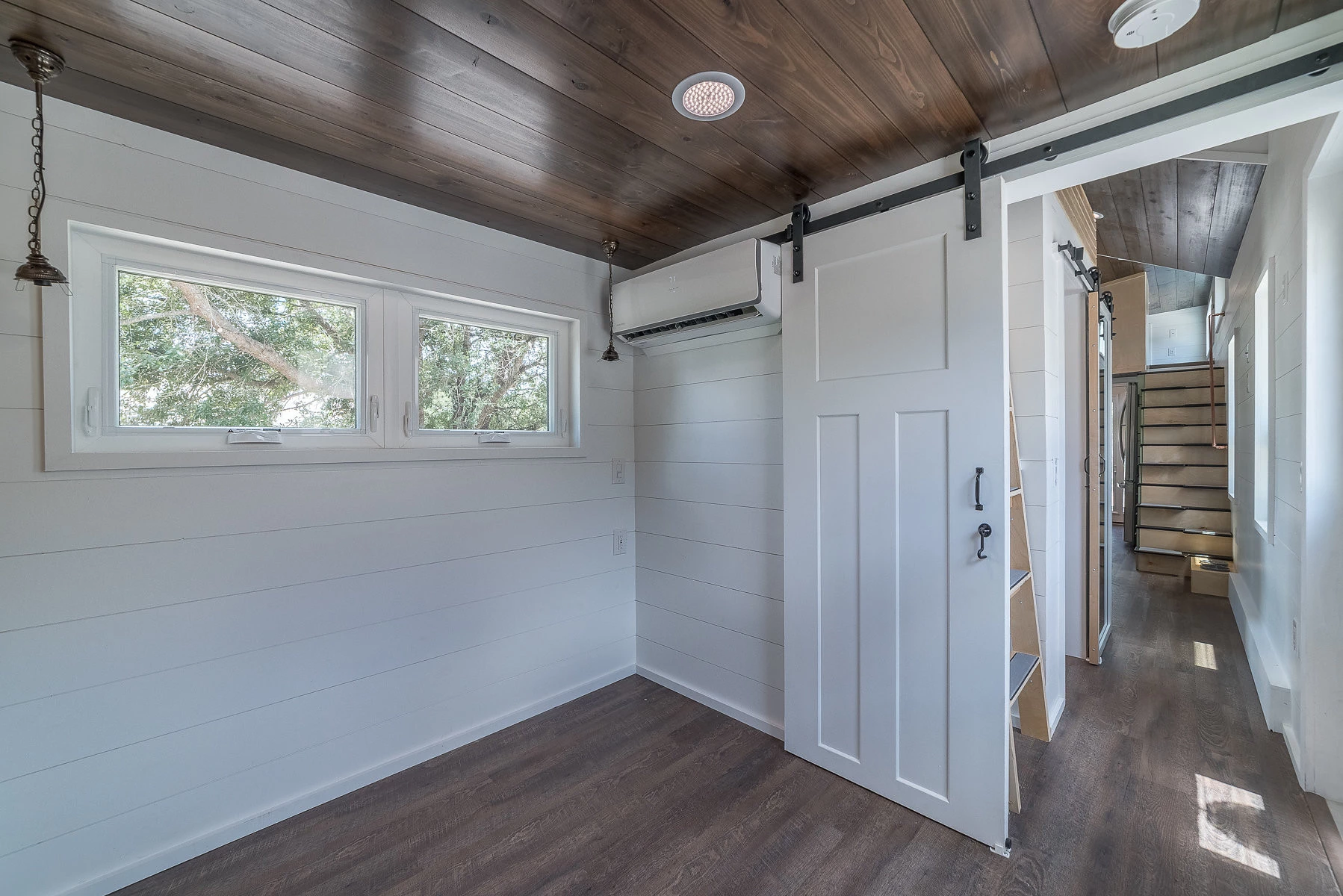 The master bedroom is located at the rear on the ground floor. It also has its own climate control, separate from the other four mini-split units. This bedroom apears to have enough ceiling height for standing with ample closet and drawer storage