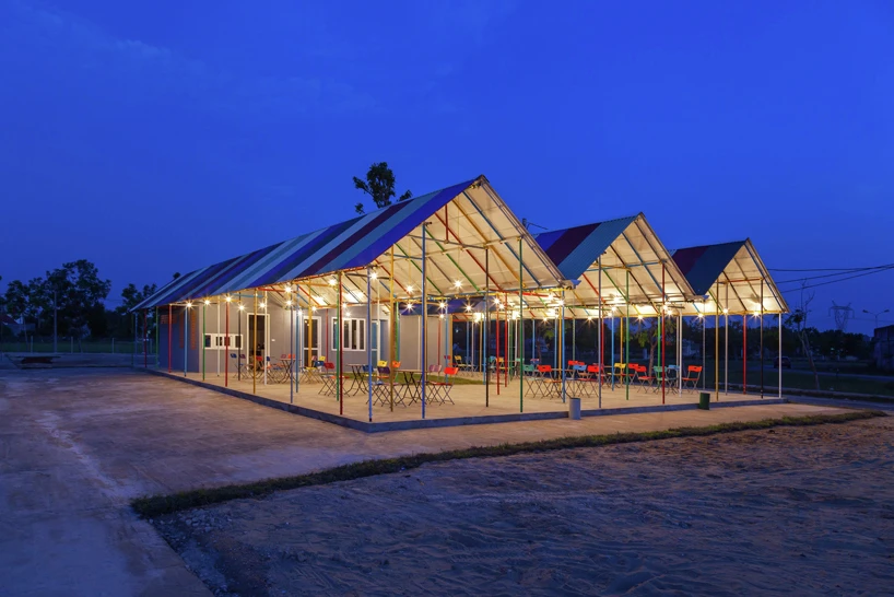 Located near a ruined stadium in a rural area within Vietnam's North Central Coast region, Re-ainbow consists of a small building with three large multicolored corrugated metal roof shelters