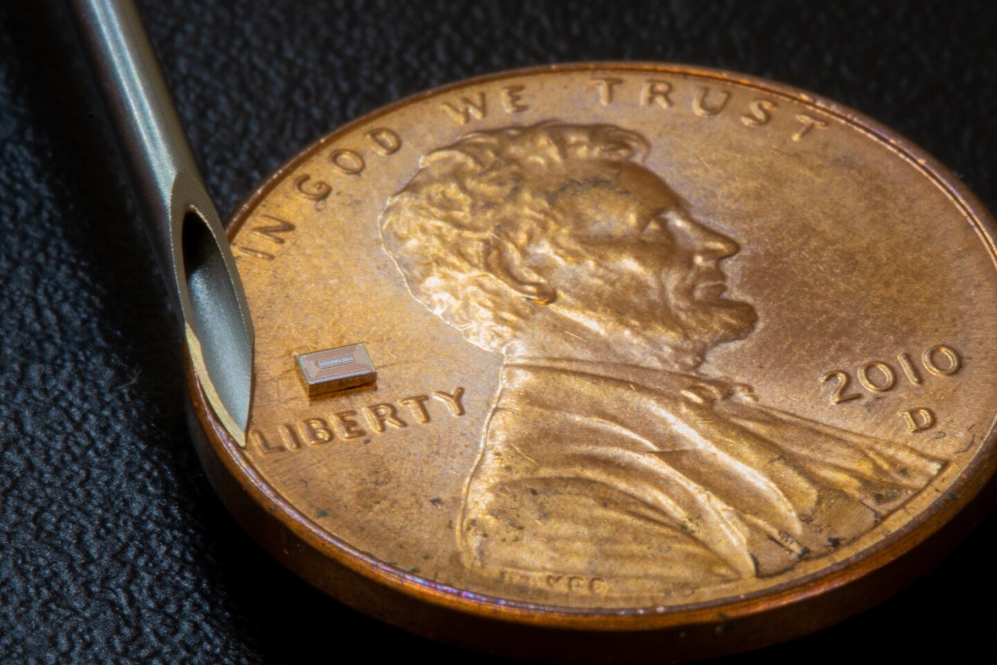 The size of the chip, as compared to a penny and a 16-gauge needle