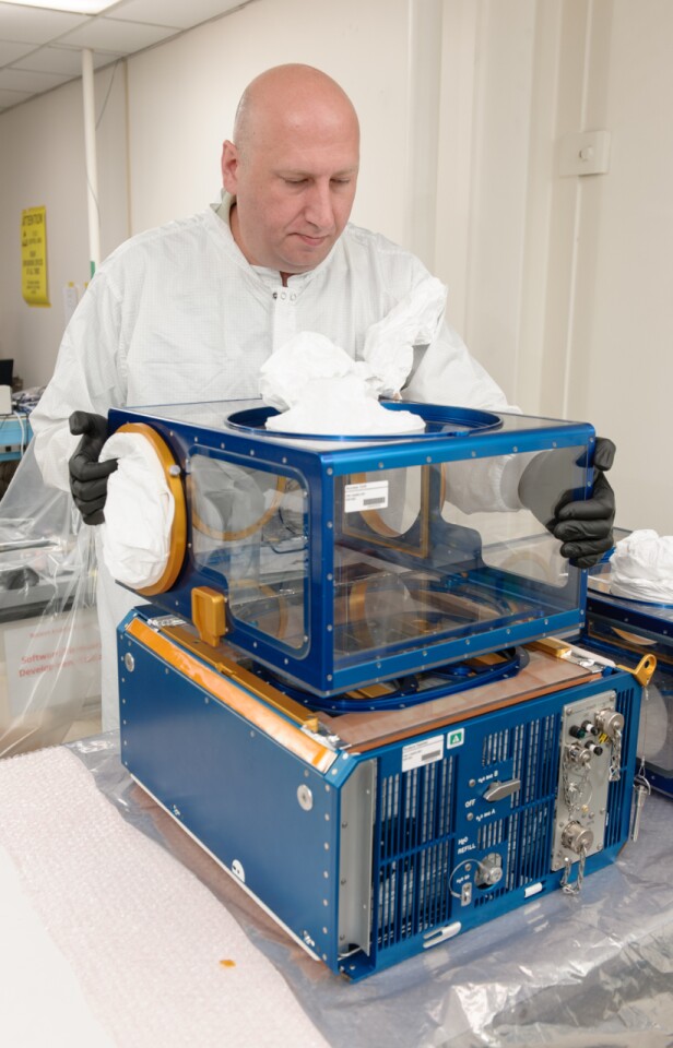 Lockheed Martin engineer Robert Benzio conducts a fit check with two Rodent Research modules (Image: NASA/Dominic Hart)