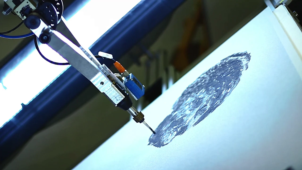 The robot's work is constantly compared to a goal image, and analyzed in software to determine the next brush stroke