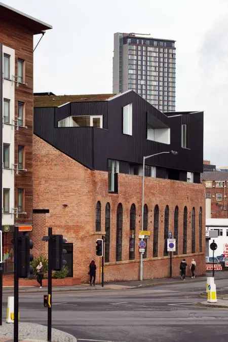 From architects Project Orange comes this fascinating extension on top of an old Victorian industrial brick building. The new black roof literally cuts through the original shell with the parasite completely overwhelming its host