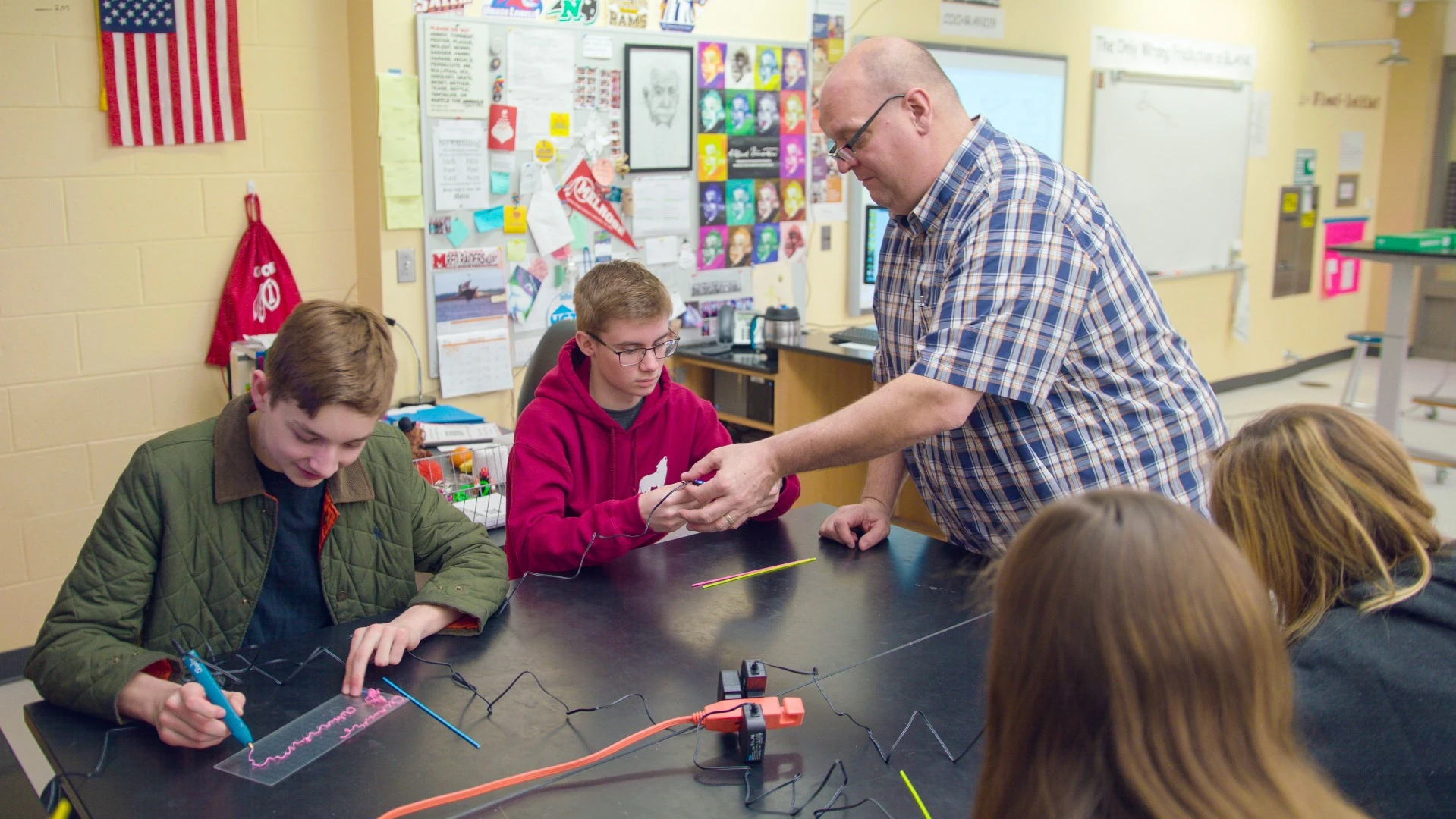 A teacher assisting students while they get to grips with a 3Doodler Create+ EDU Learning Pack