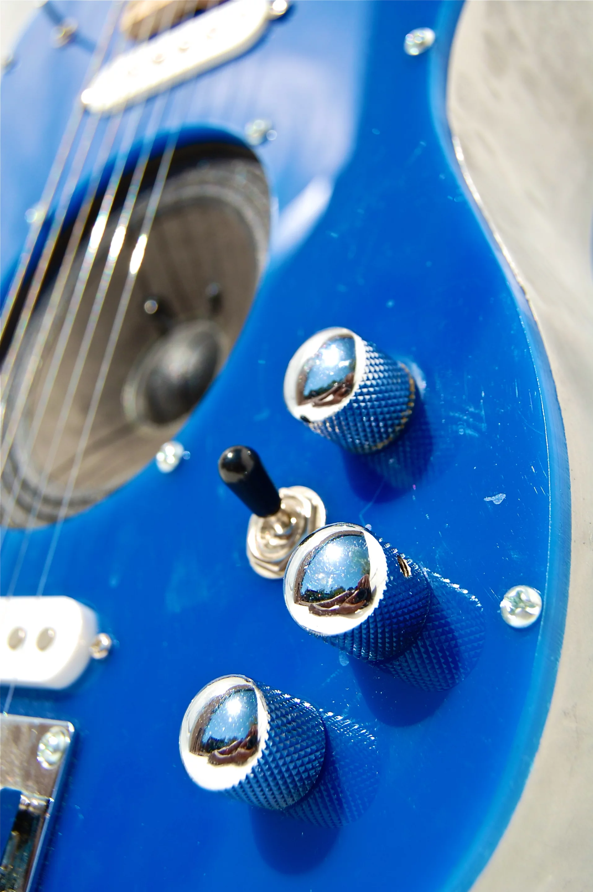 The guitar has three knobs circling the three-way toggle switch pickup selector, one for volume, one for gain and the other is an on/off switch