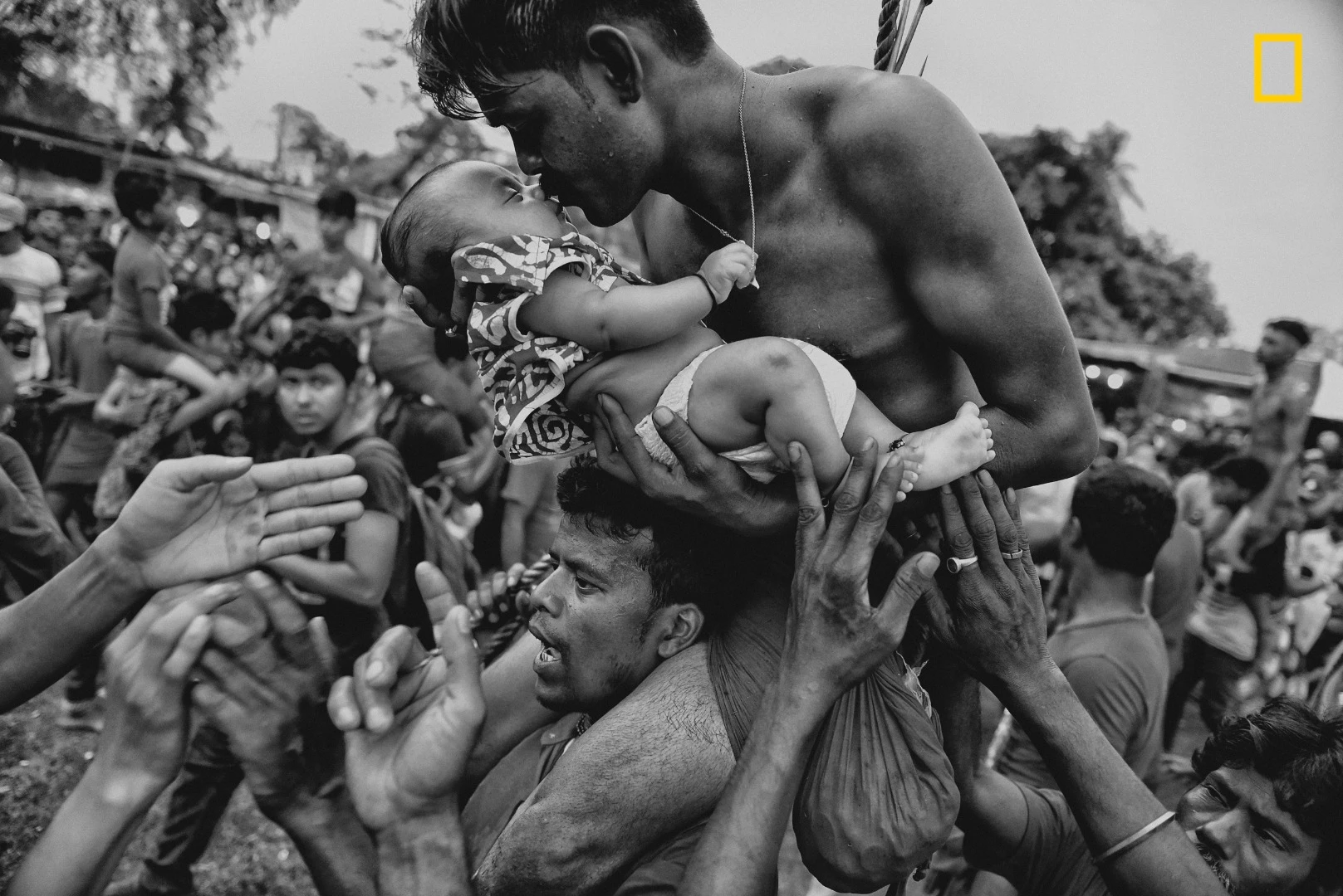3rd Place - People. A Hindu devotee kisses his newborn baby during the Charak Puja festival in West Bengal, India. Traditional practice calls for the devotee to be pierced with a hook and sometimes swung from a rope. This painful sacrifice is enacted to save their children from anxiety. While covering the festival, I was able to view the religious practice from the perspective of Hindu devotees. I tried to capture the moment of love and bonding between a father and his child—and show a father’s concern for his little son.