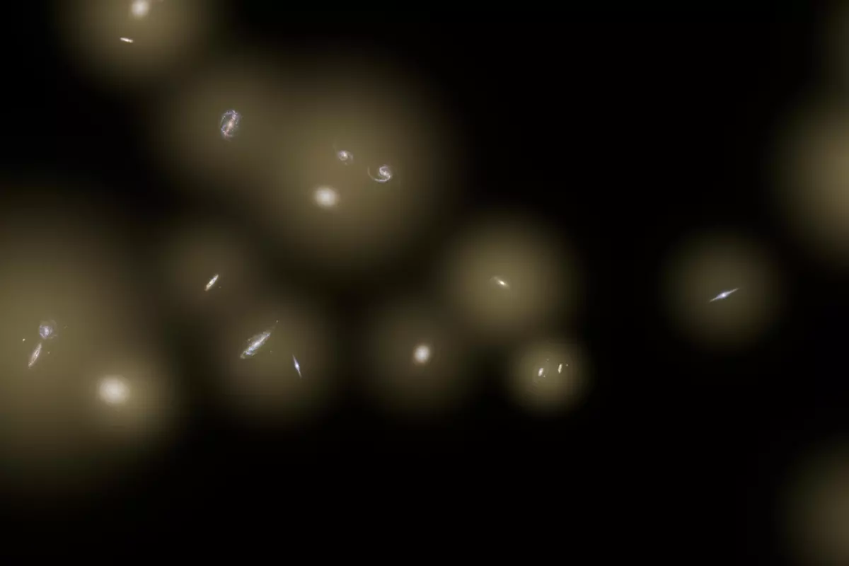 An artist's impression of a background glow caused by unseen stars hiding between galaxies