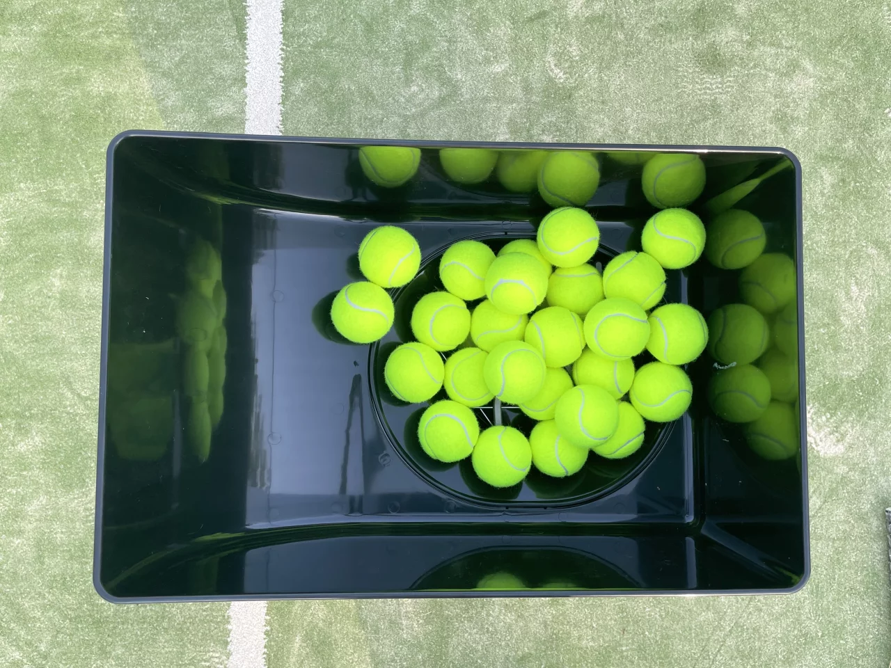 The container can hold 150 balls, which feed into the chute system below