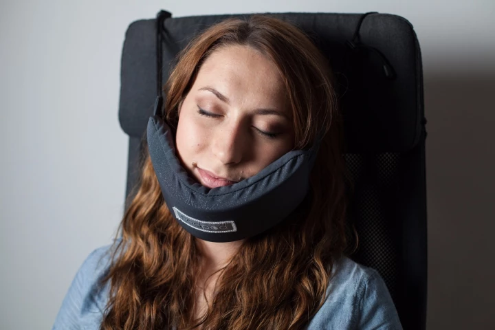 The NodPod comprises cords that slip over the rear of a seat or headrest to secure a support upon which the user rests her chin