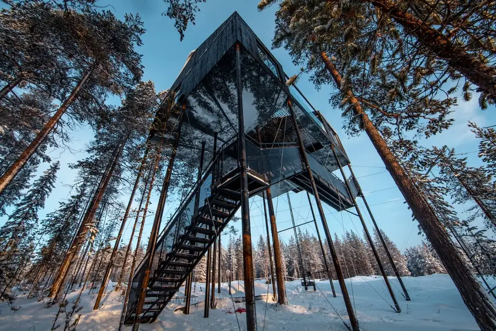 Raised 10 m (32 ft) above a forest floor in Swedish Lapland, the luxury 7th Room treehouse lets visitors sleep out under the stars on a netted terrace