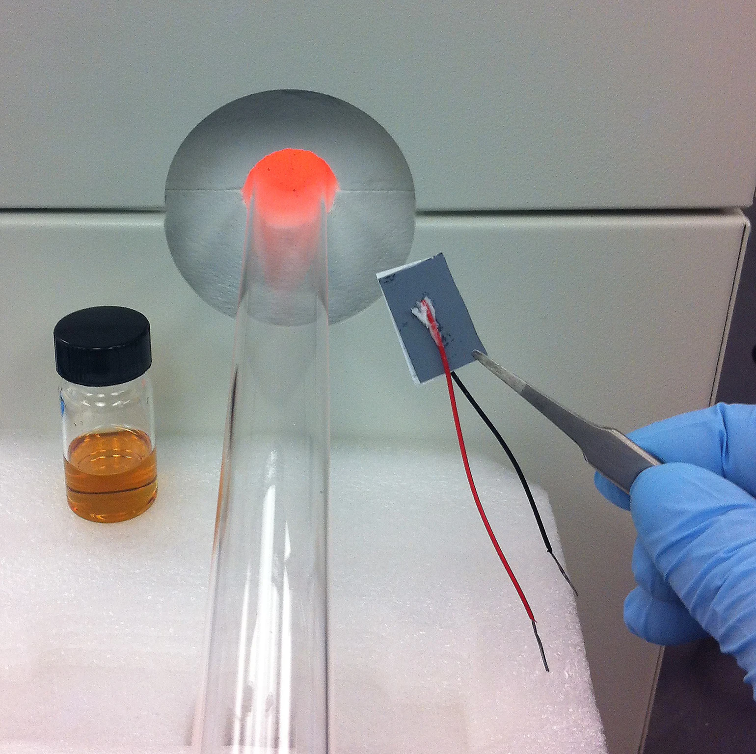 On the left, the electrolyte used in the supercapacitor; in the middle, the furnace that was used to deposit graphene; on the right, a silicon supercapacitor (Photo: Landon Oakes/Vanderbilt University)