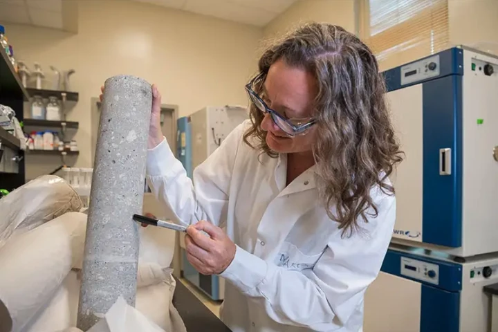 Lead author Julie Maresca with one of the concrete cylinders studied