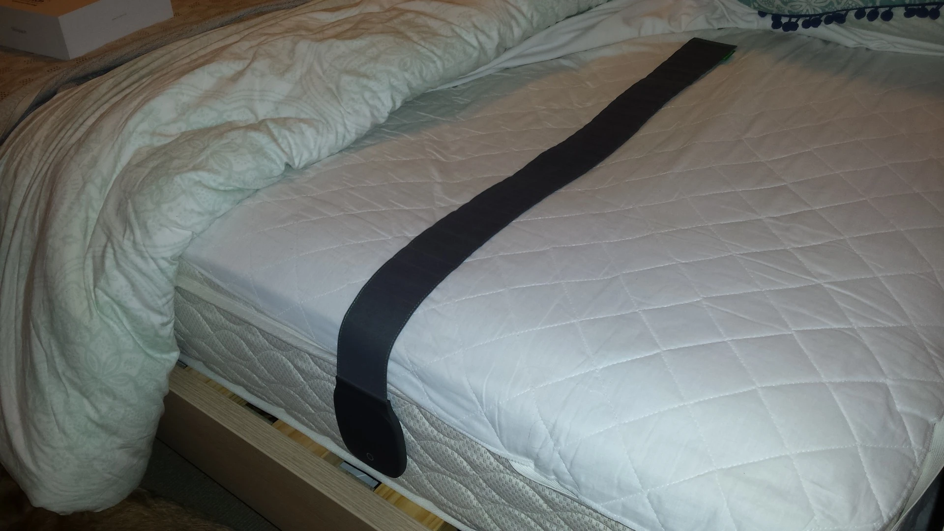 The monitor lies across your mattress, under the fitted sheet