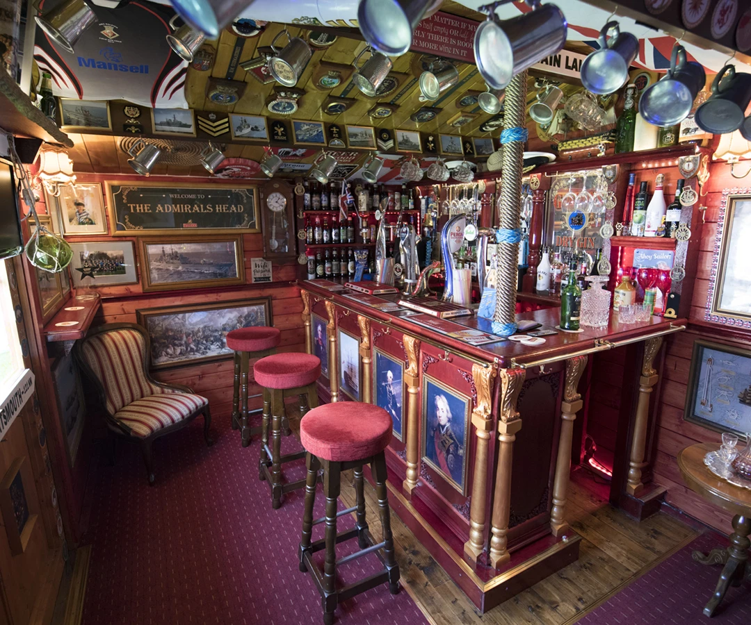 The Admiral’s Head is filled with vintage naval pub memorabilia - including hanging mugs, pub mirrors, vintage bottled ales, and more