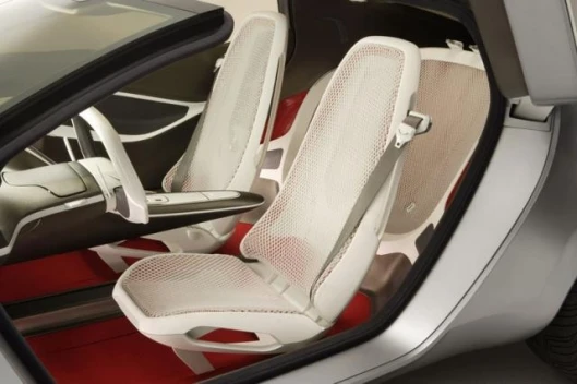 The interior of the Ford Reflex concept features lightweight inner seat frames wrapped in mesh. The white mesh fabric is offset with warm red carpeting.