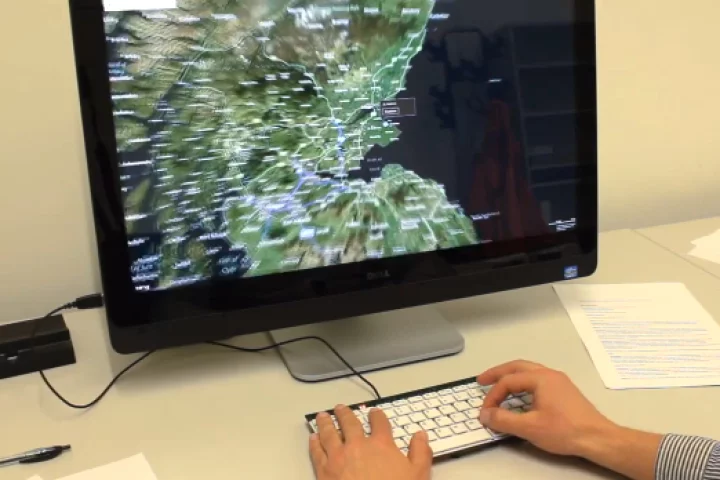 A user zooms in on a map by pinching their fingers on the keyboard