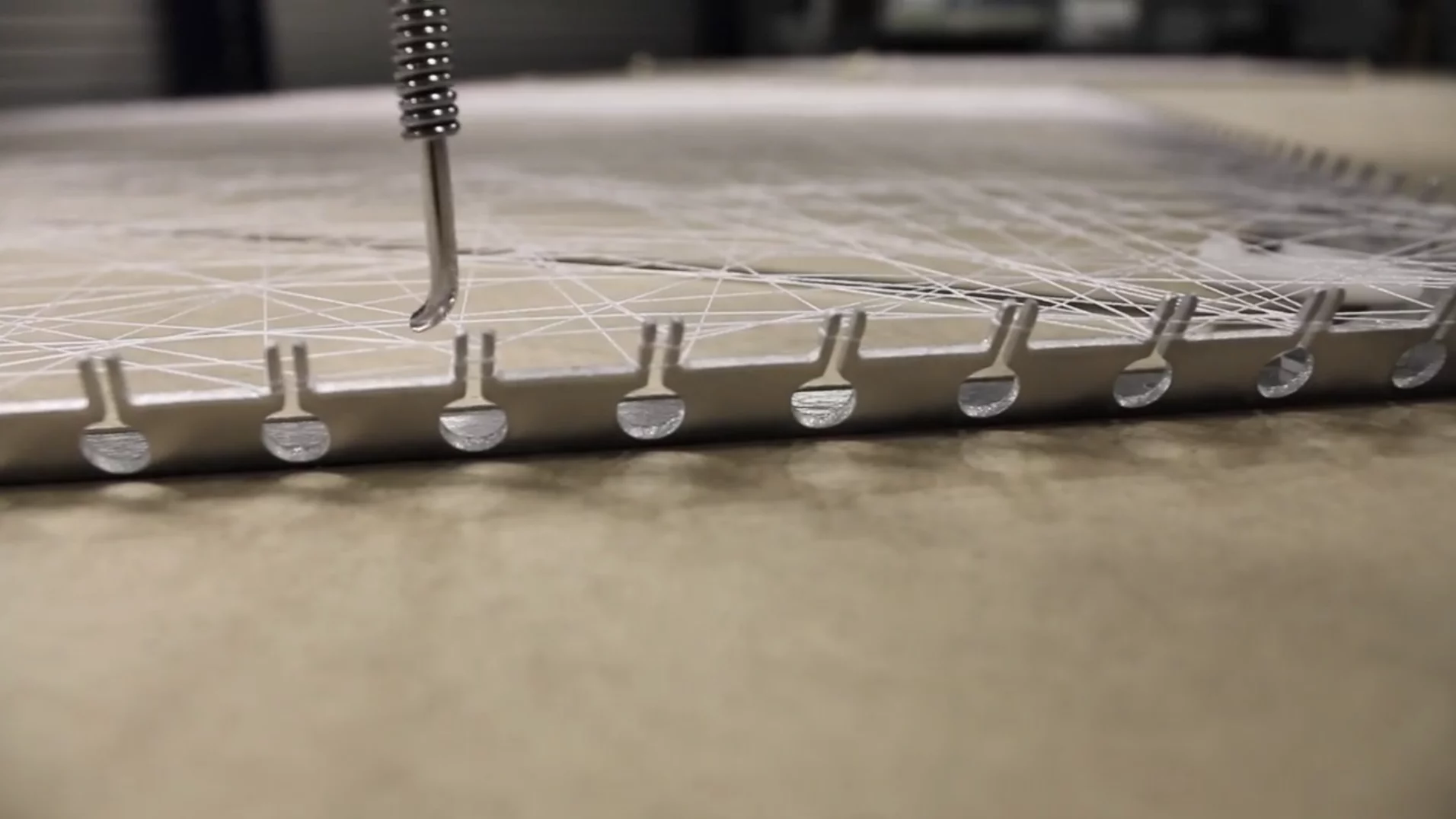 A computer numerical control (CNC) machine threads silk about these teeth to create a silky lattice (Video still: Mediated Matter Group)