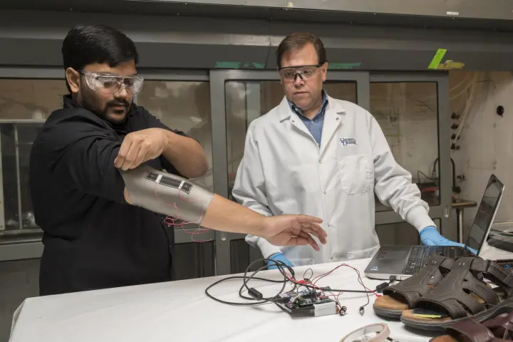 Sagar Doshi (left) and Erik Thostenson test an elbow sleeve made with the material