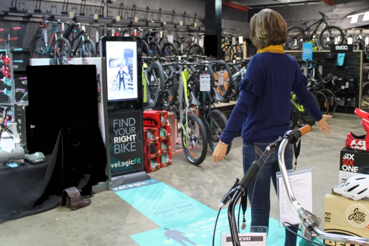 Bike buyers stand in front of the Right Bike kiosk and are measured up before the system helps them choose a bike that fits their needs