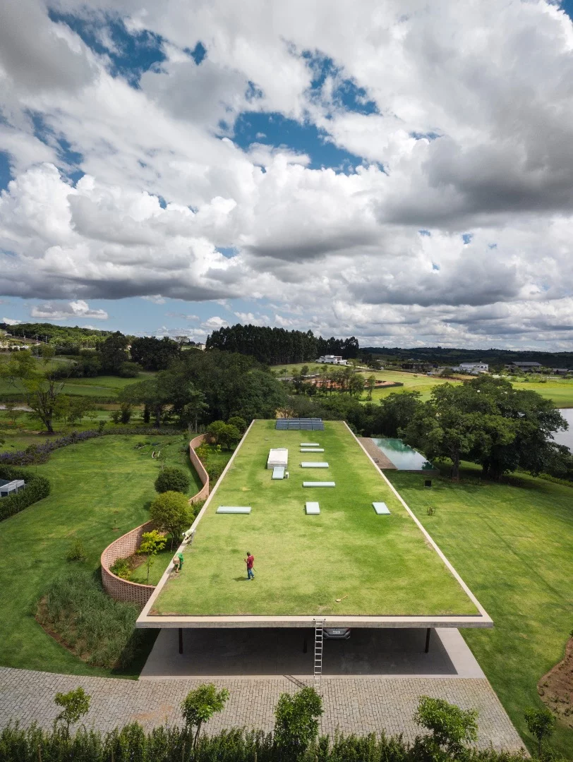 Planar House is topped by a concrete roof that's covered in greenery and designed to blend in with its landscaped garden