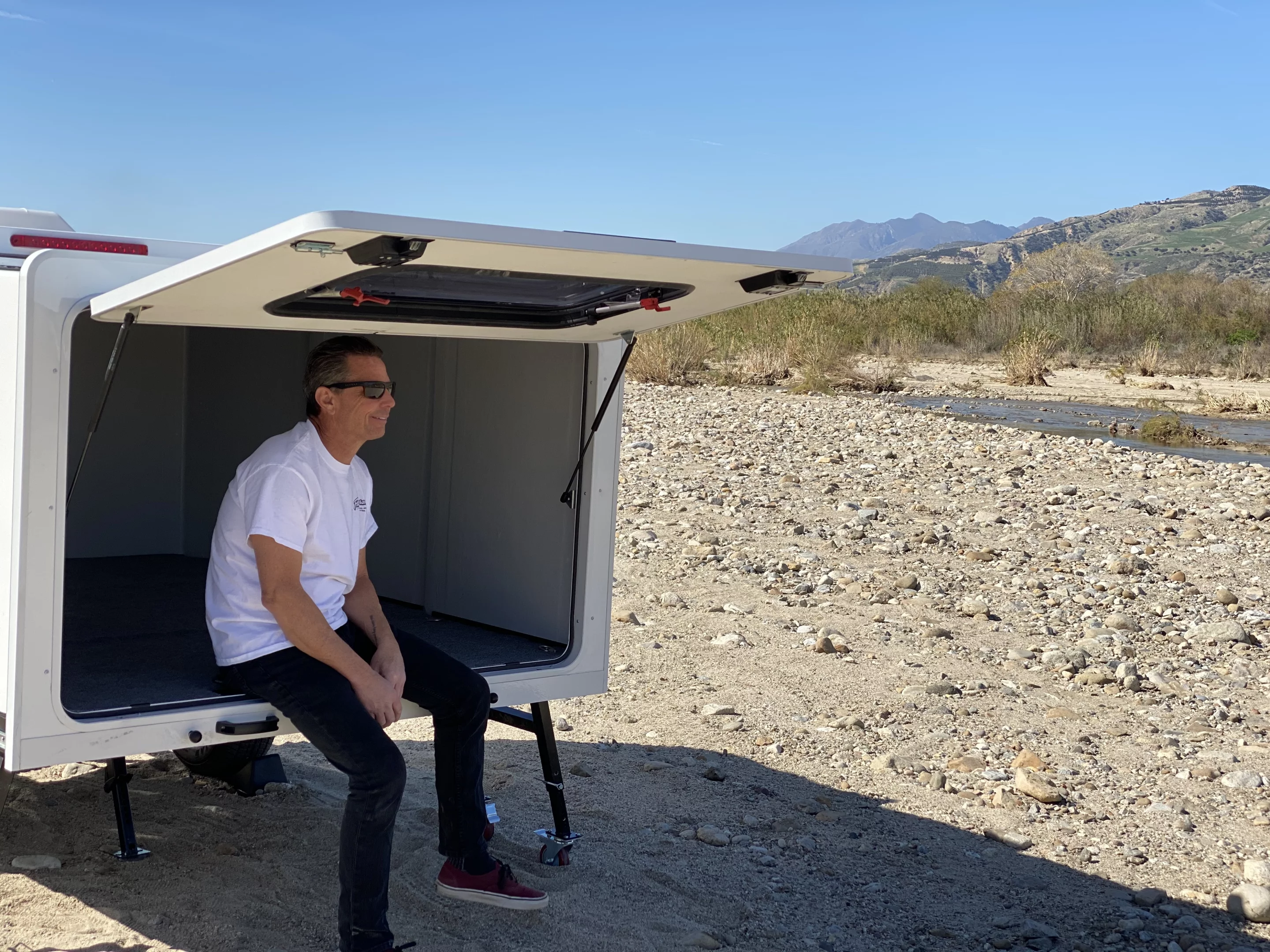 The Hitch Hotel is really more like a hard-sided tent than a full camping trailer, offering a sheltered space for two+ adults and a window and fan