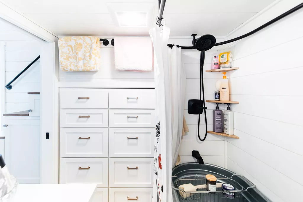 The bathroom in Jen's 34' x 10' Tiny Home has storage space for clothing
