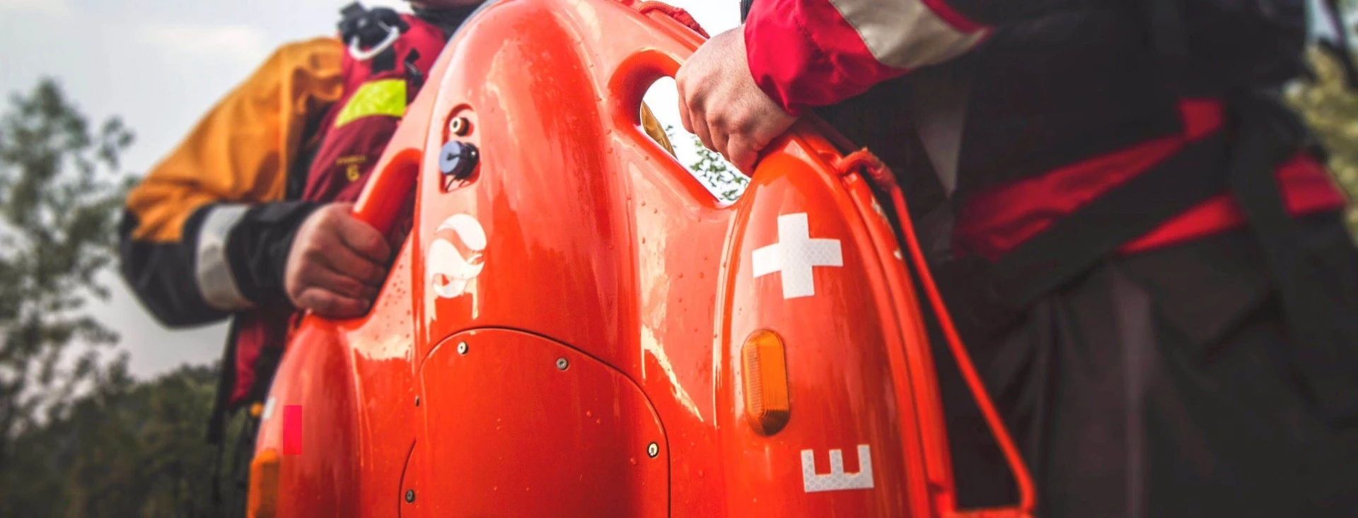 The Dolphin 1 has ropes around the edge of the bright orange plastic hull, and carry handles on the nose