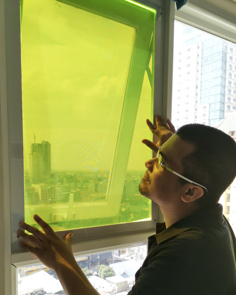 Carvey Ehren Maigue, inventor of the AuREUS System Technology, fits a panel of the material into a window