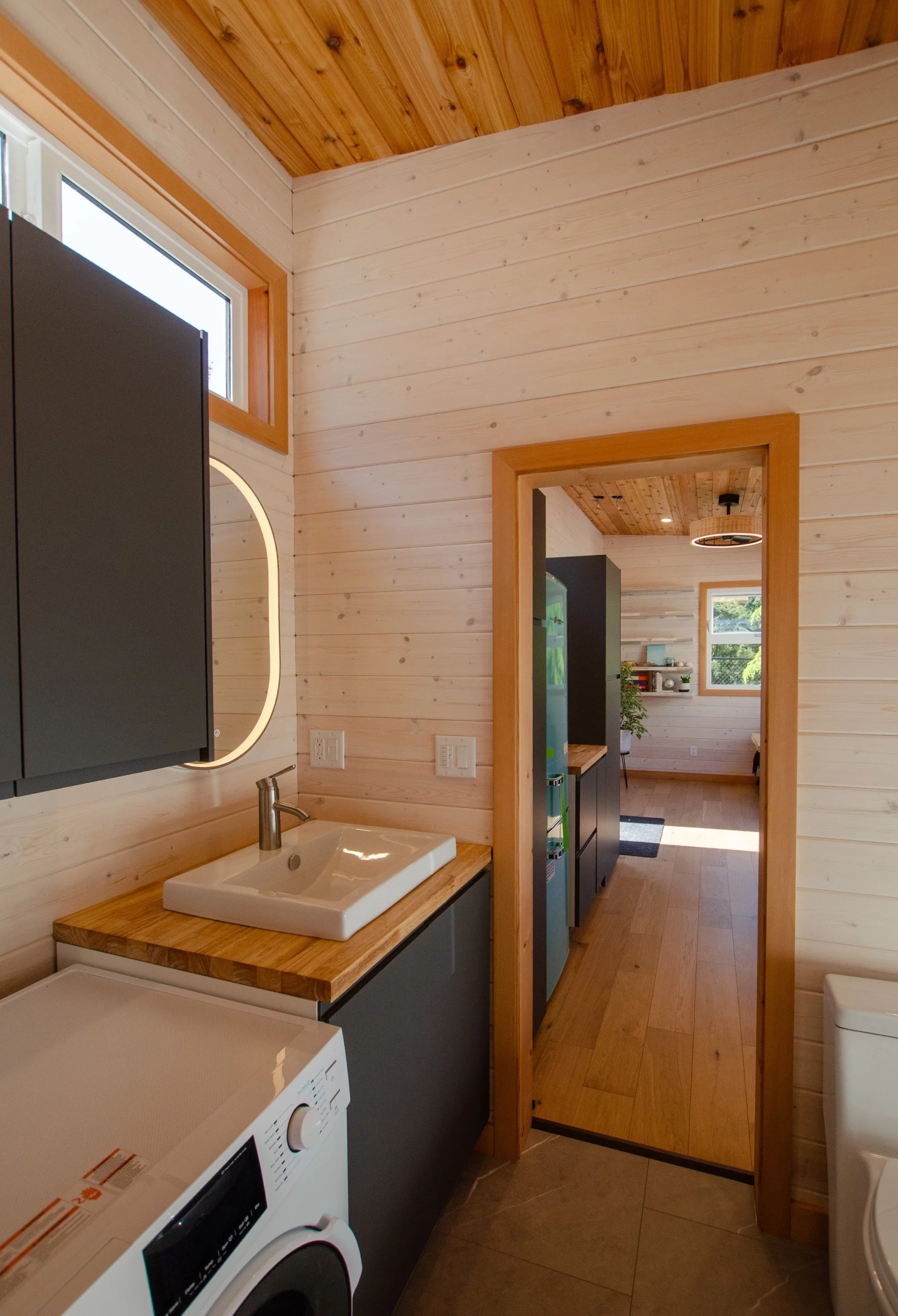 The Juniper's bathroom includes a washer/dryer, a sink, and a flushing toilet