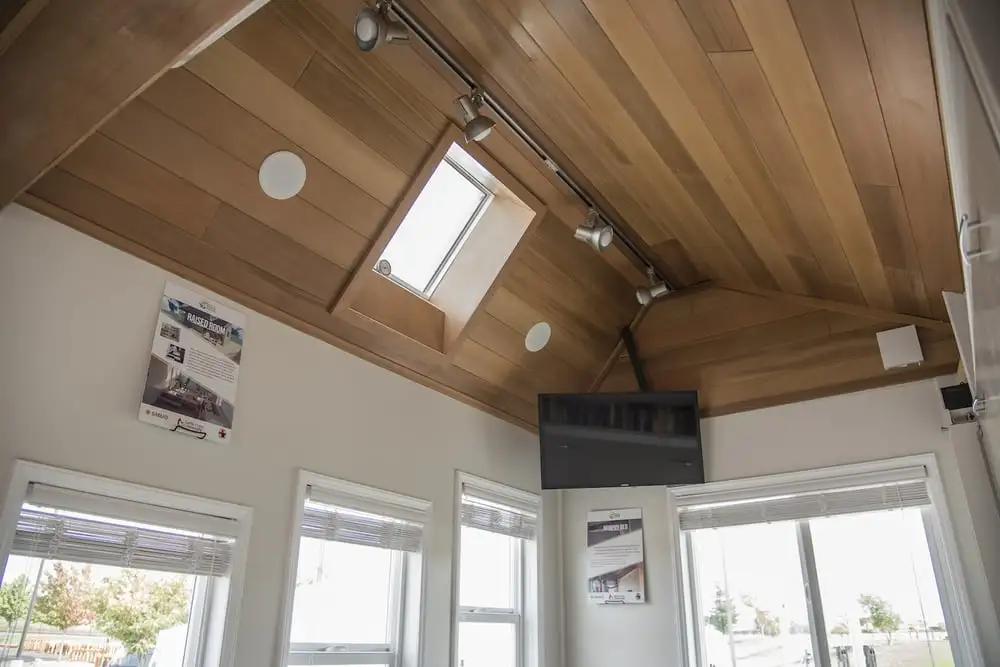 The interior of the Revolve House includes a kitchen and dining area with pull-down table, a wet-room style bathroom, and a lounge/bedroom with murphy-style bed