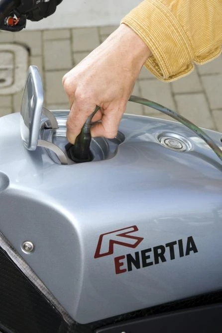 Brammo's Enertia e-bike charges through a standard power plug beneath a hatch in the "tank."