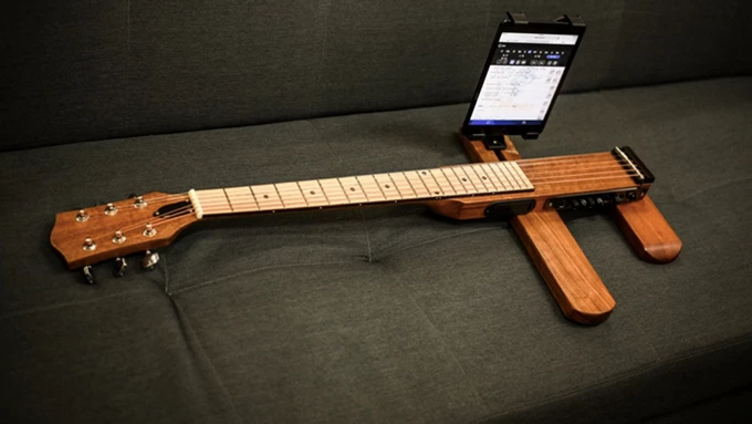 The Cross Guitar 2.0 comes with a smartphone mount to make learning from videos easier
