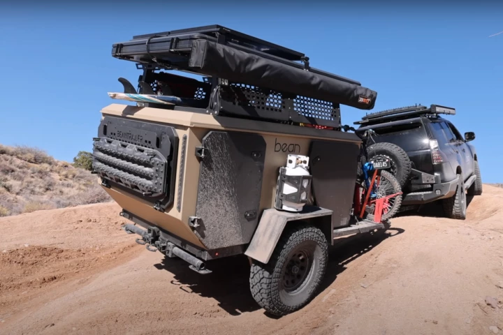 Something of a shrunken off-road squaredrop trailer, the Bean Pod sleeps gear instead of people, moving the human campers up top