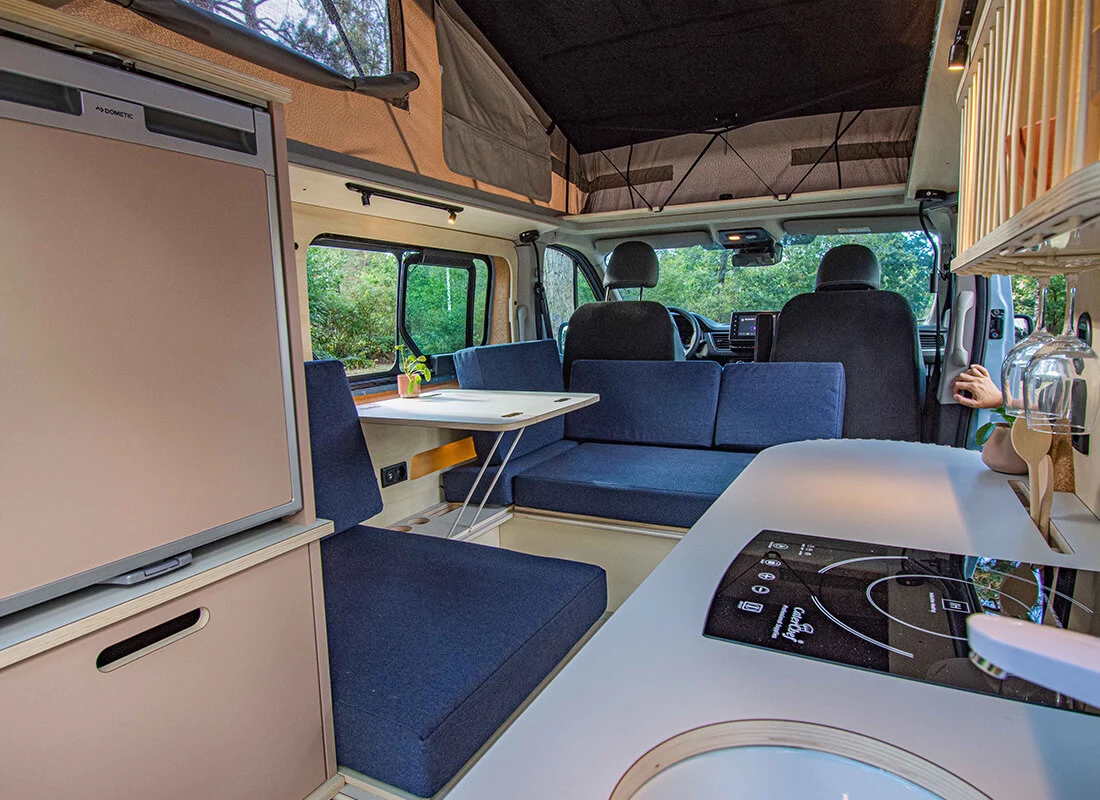 The fridge is located in a floating console across from the main kitchen block
