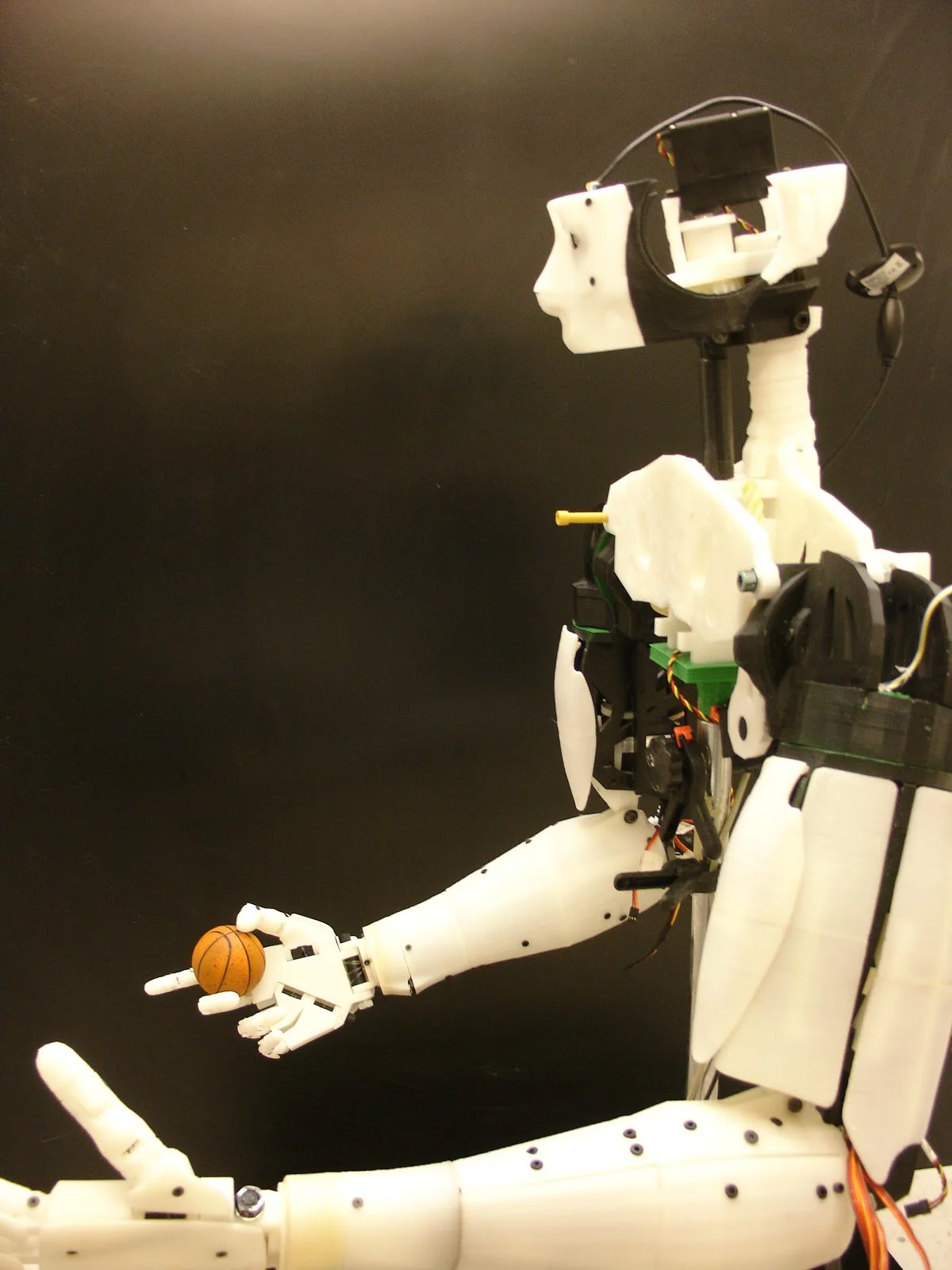 InMoov holds a miniature basketball