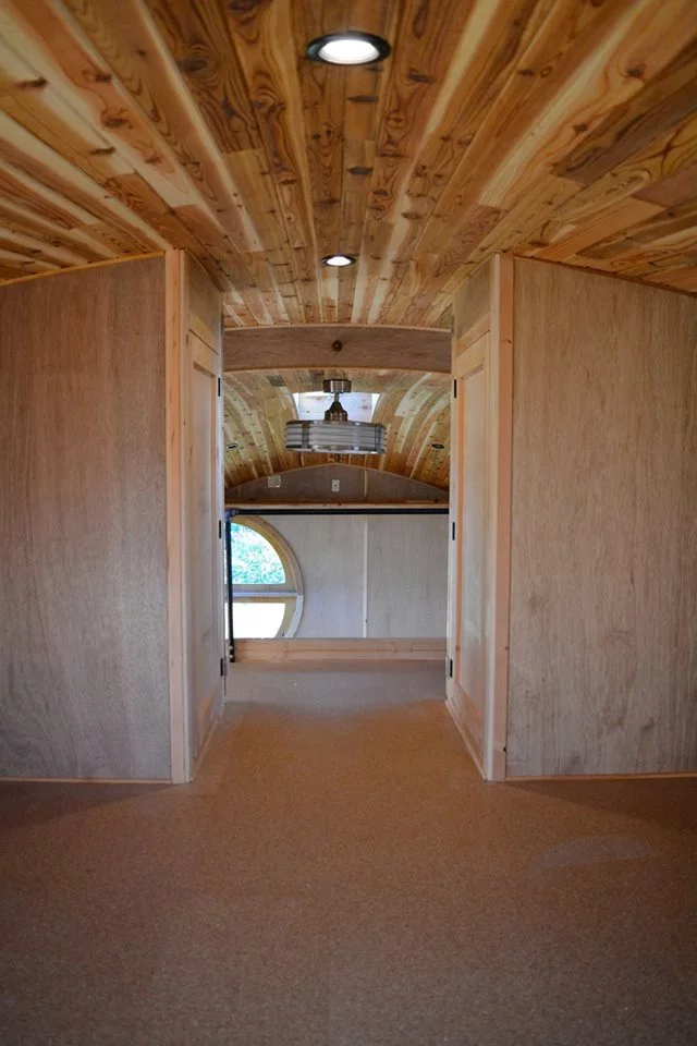 The bedroom, with an unusually high ceiling for a tiny house