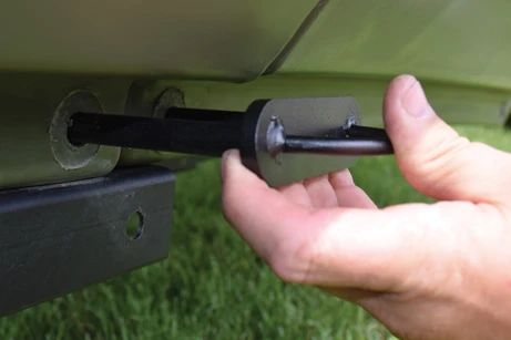 Flipping the connector bolt simultaneously detaches the front of the trailer from the frame and connects the two halves of the boat