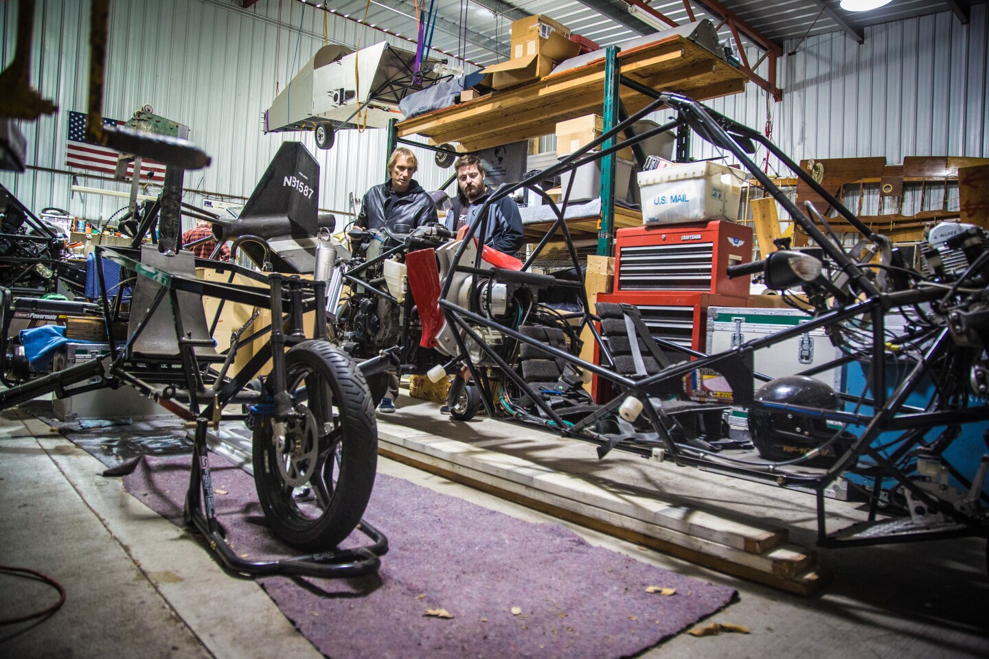 Loz Blain and Dezso Molnar looking over the GT and G2 gyrocycles in a hangar in Los Angeles