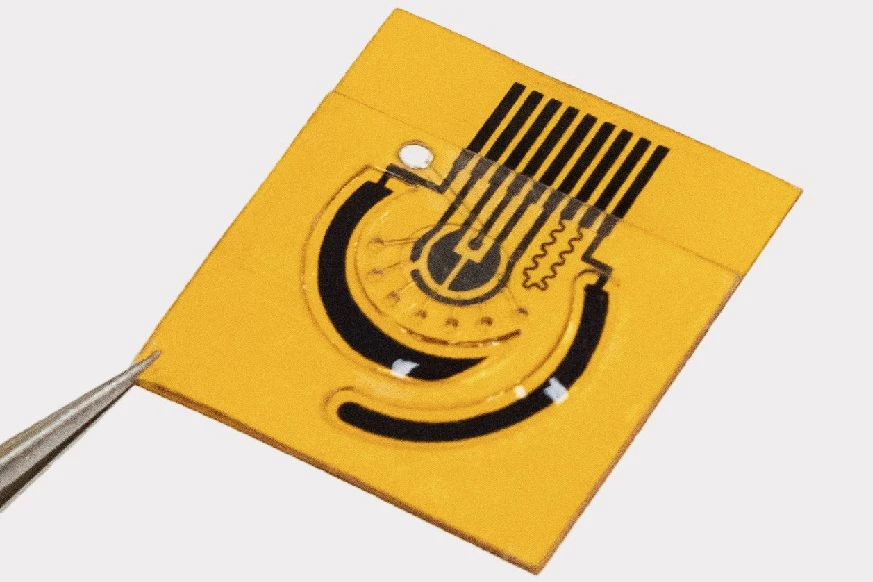 The sensor stimulates sweat production using two electrodes (the large curved sections)