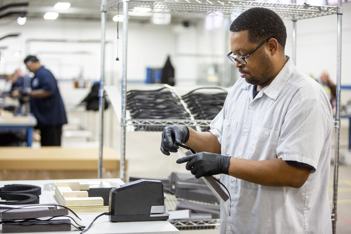 Operators and assemblers assemble medical face shields to aid the coronavirus response
