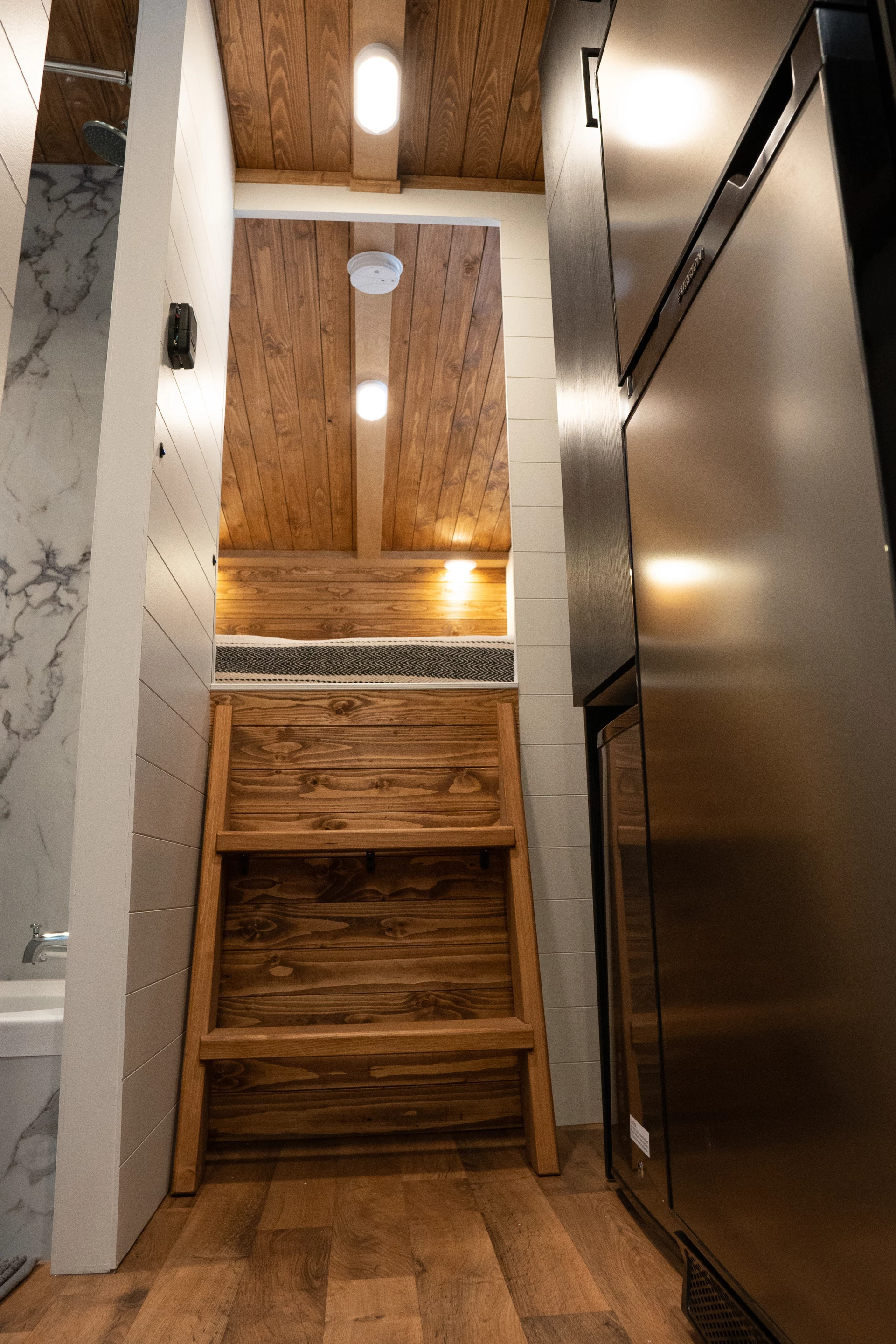 The Nomad 5th Wheel's bedroom is reached by wooden steps