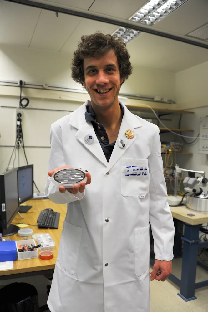 IBM scientist Colin Rawlings holds a silicon wafer with dozens of tiny lithography probes