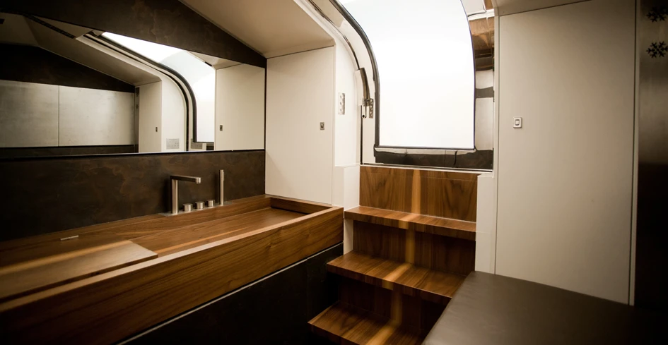 Below deck resides a large air-conditioned interior with storage space, bathroom, cushioned seating and wooden work bench