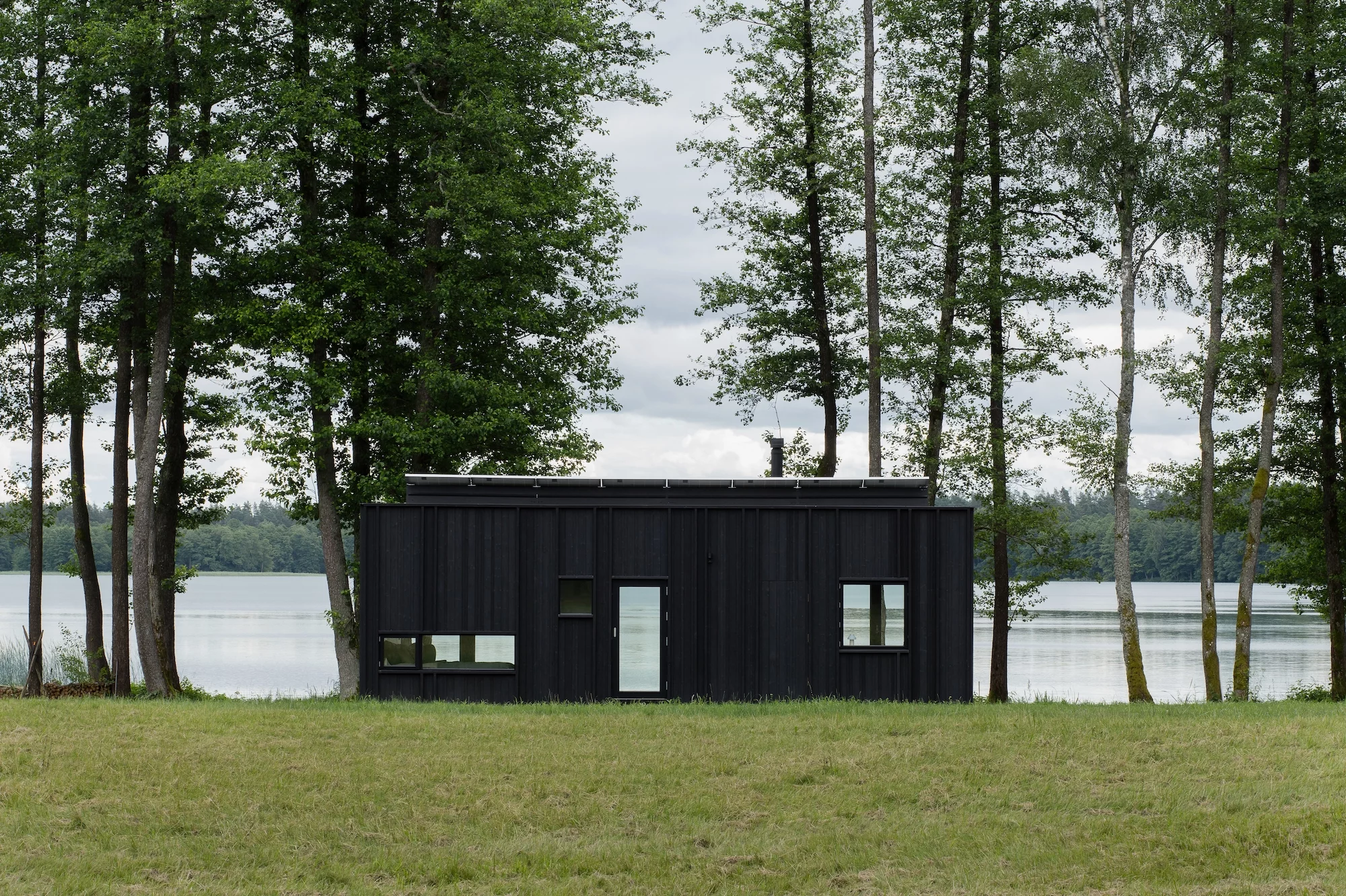 The Konga off-grid cabin is finished in wood, which has been charred to preserve it and protect it from insects, lending it a distinctive dark appearance
