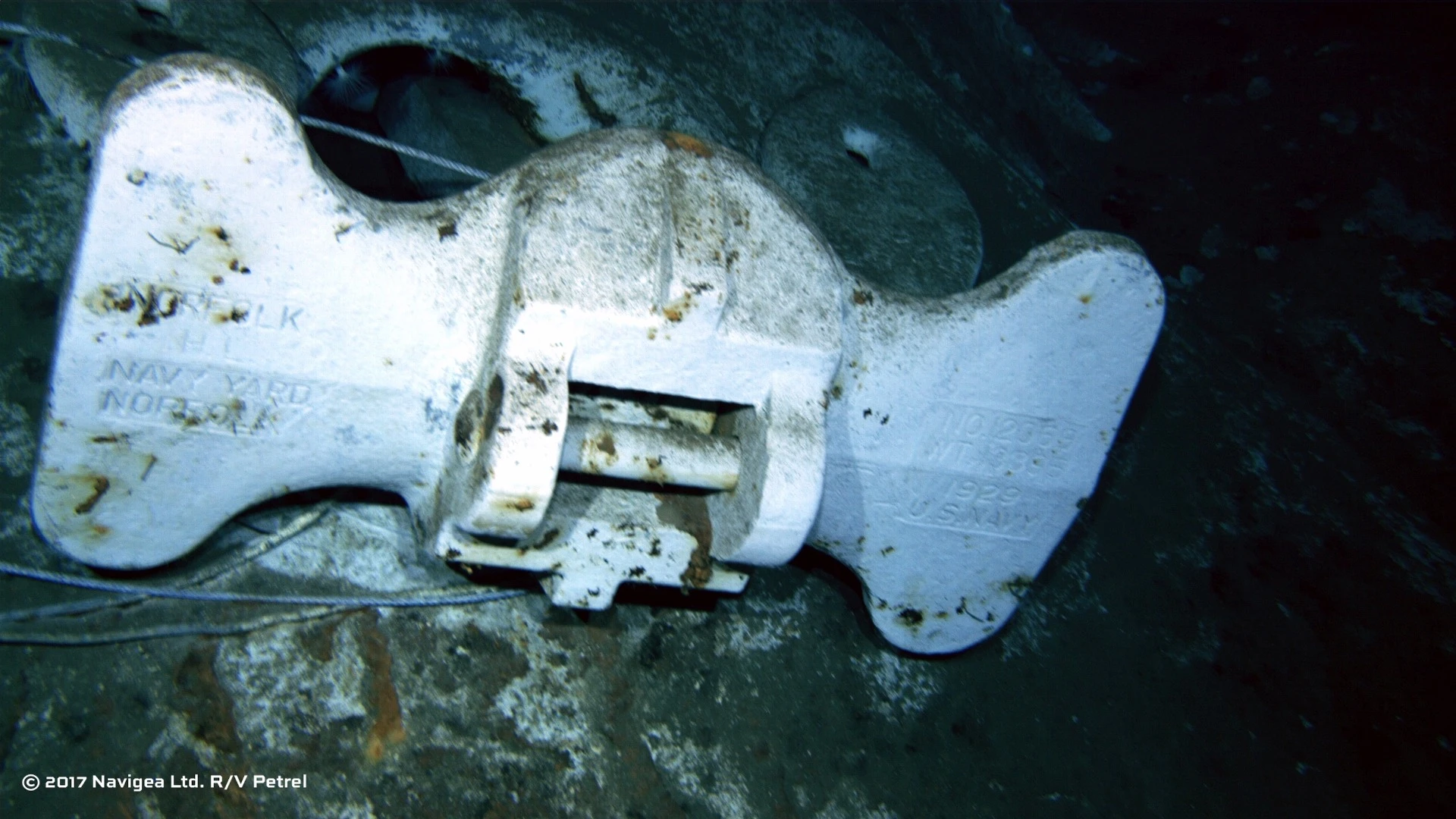 An image shot from a remotely operated vehicle shows the bottom of an anchor clearly marked "US Navy"