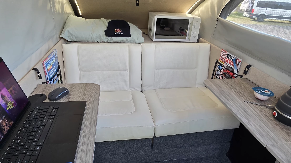 At night, the shelves fold up and the two-seat sofa drops down into a double bed