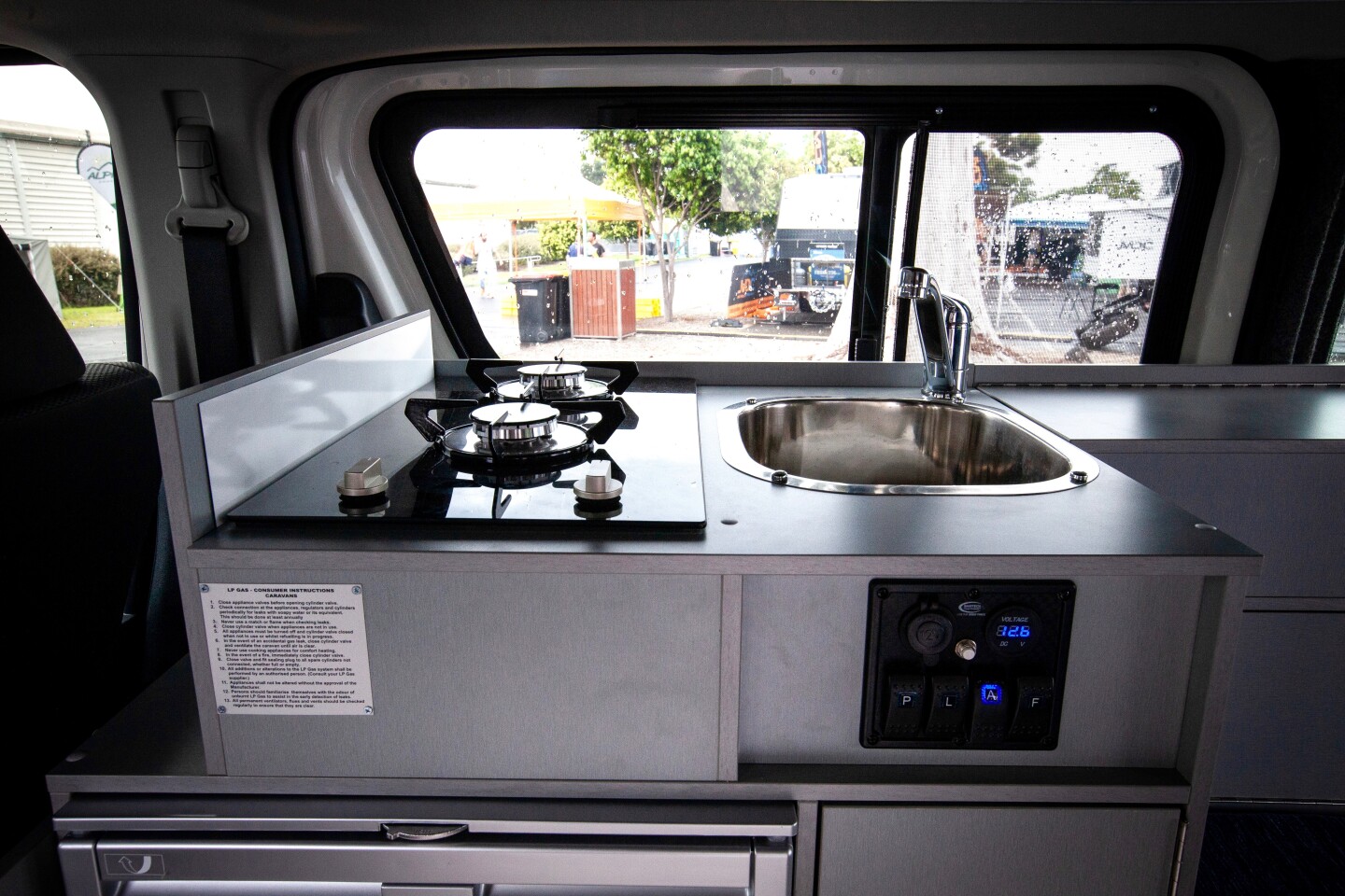 The kitchen includes a dual-burner gas stove, fridge/freezer and sink