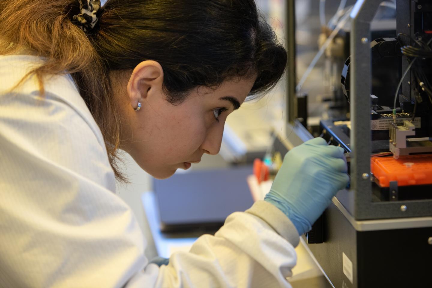 University of Cincinnati research assistant Shima Dalirirad examines a machine that prints test strips in UC's Nanoelectronics Laboratory