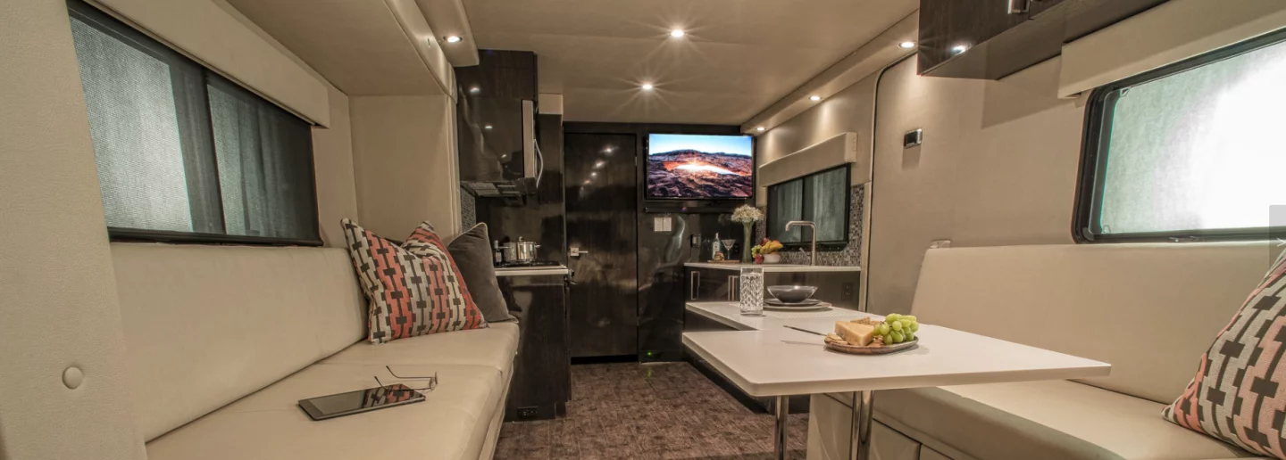 The interior includes modular tables, a kitchen and a rear entertainment lounge